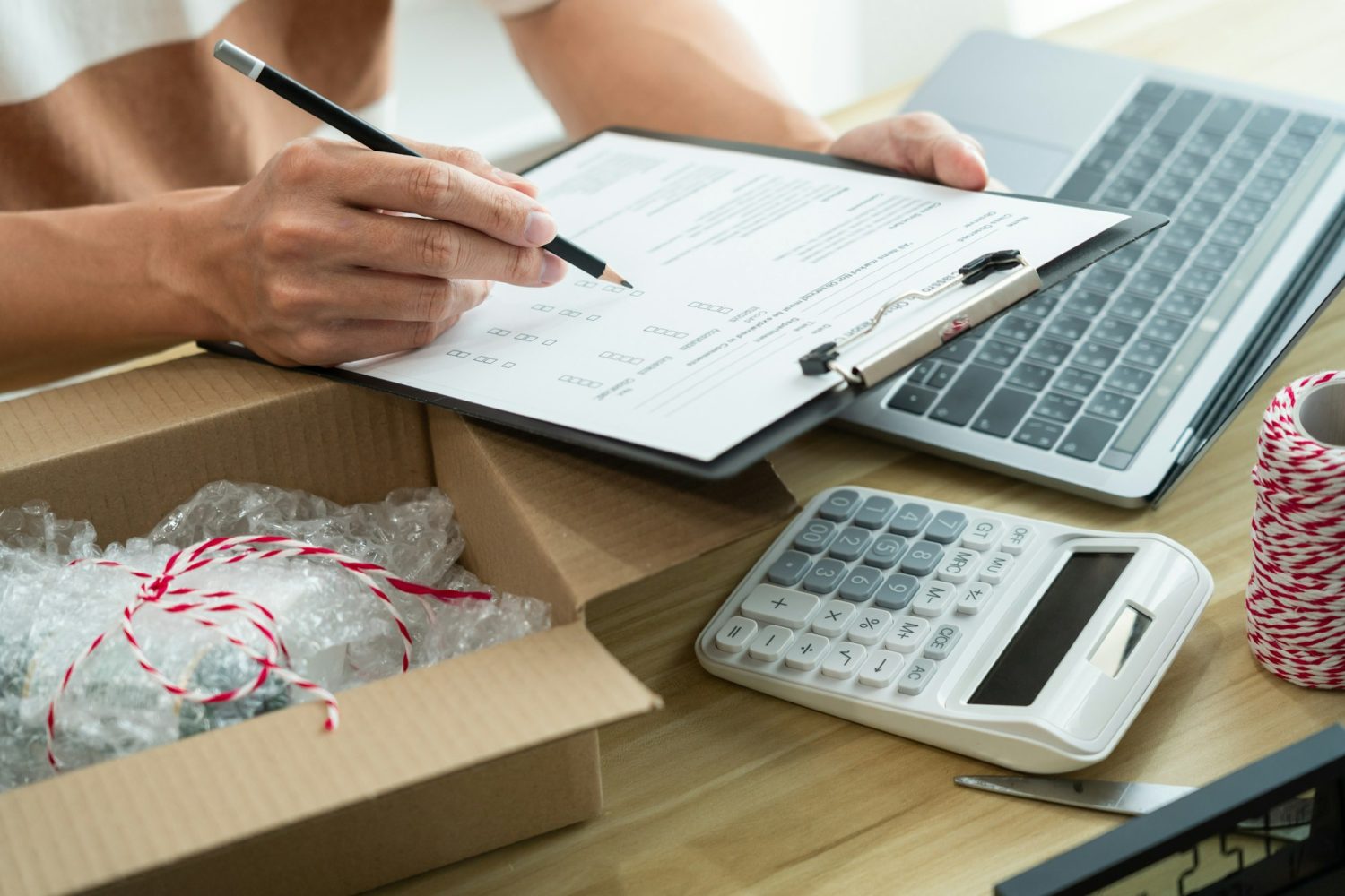 selling agent writing down a product report and checking his product in the parcel.