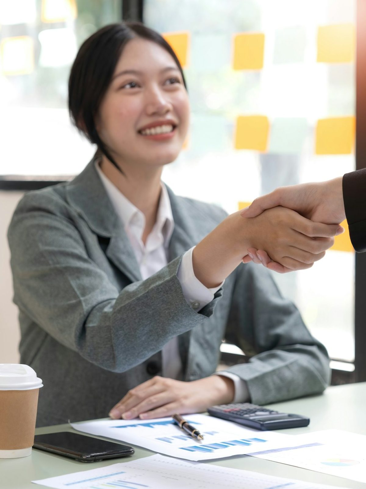 Two Asian businesswomen are shaking hands in the office. business cooperation, business dealing